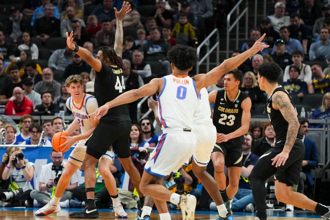 Florida Gators forward Alex Condon (21) looks for an open man on Friday, March 22, 2024, during the first round of the NCAA Men’s Basketball Tournament at Gainbridge Fieldhouse in Indianapolis. The Colorado Buffaloes defeated the Florida Gators 102-100.