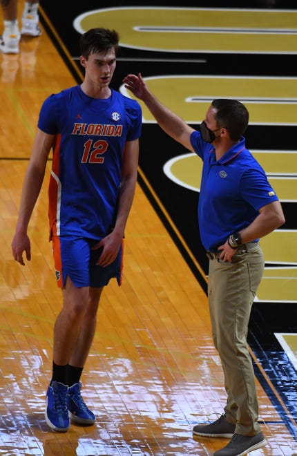 Dec 30, 2020; Nashville, Tennessee, USA; Florida Gators forward Colin Castleton (12) is congratulated by head coach Mike White after defeating the Vanderbilt Commodores at Memorial Gymnasium. Mandatory Credit: Christopher Hanewinckel-USA TODAY Sports