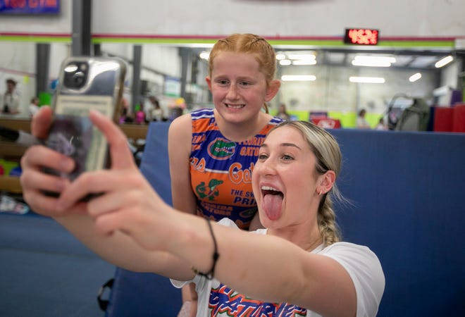 Kinley Wright, 11, gets a selfie with team member Payton Richards as the University of Florida gymnastics team put on a gymnastics clinic at Balance 180 gymnastics in Gainesville, FL on Saturday, March 25, 2023. More than 100 young gymnasts learned gymnastics training and routines. They also  met the gymnasts to get autographs and pictures at the NIL Gatorverse event. [Alan Youngblood/Gainesville Sun]