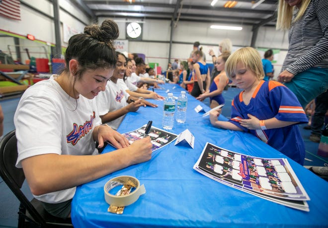 Bjorn Yonger gets team member Kayla DiCello’s autograph as the University of Florida gymnastics team put on a gymnastics clinic at Balance 180 gymnastics Gainesville, FL on Saturday, March 25, 2023. More than 100 young gymnasts learned gymnastics training and routines. They also  met the gymnasts to get autographs and pictures at the NIL Gatorverse event. [Alan Youngblood/Gainesville Sun]