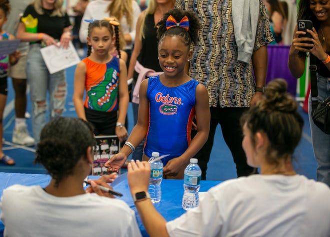 Caci Jones, 7, gets team member autographs as the University of Florida gymnastics team put on a gymnastics clinic at Balance 180 gymnastics Gainesville, FL on Saturday, March 25, 2023. More than 100 young gymnasts learned gymnastics training and routines. They also  met the gymnasts to get autographs and pictures at the NIL Gatorverse event. [Alan Youngblood/Gainesville Sun]
