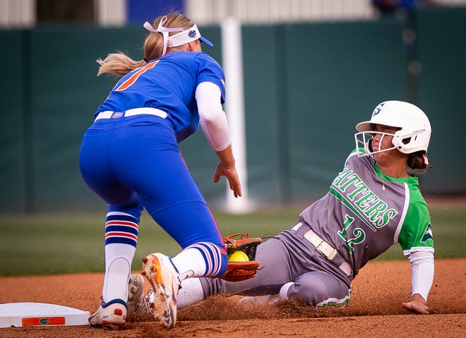 Stetson utility Alyssa Gilman (12) slides safe into second as Florida infielder Skylar Wallace (17) tries to tag her out in the top of the first. The Florida women’s softball team hosted Stetson at Katie Seashole Pressly Stadium in Gainesville, FL on Wednesday, March 29, 2023. Florida won 8-0 in six. [Doug Engle/Gainesville Sun]