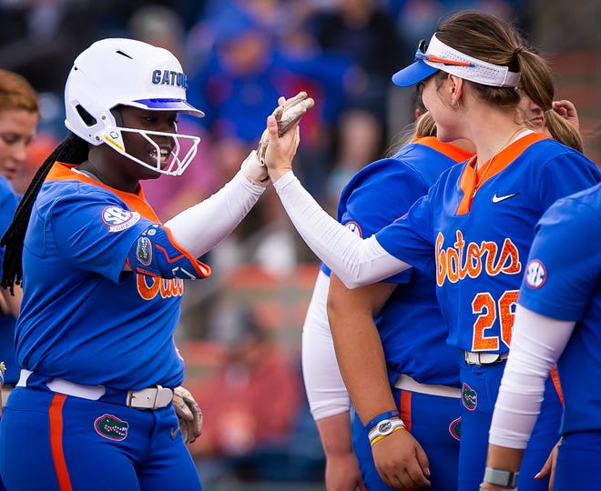 Florida third baseman Charla Echols (4) gets a high-five from Florida outfielder Christina Wellen (26) after hitting a solo home run in the bottom of the first. The Florida women’s softball team hosted Stetson at Katie Seashole Pressly Stadium in Gainesville, FL on Wednesday, March 29, 2023. Florida won 8-0 in six. [Doug Engle/Gainesville Sun]