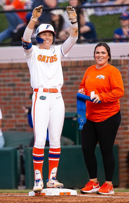 Florida infielder Skylar Wallace (17) celebrates her single in the bottom of the first on first base with First Base Coach Cassidy Brewer. The Florida women’s softball team hosted USF at Katie Seashole Pressly Stadium in Gainesville, FL on Wednesday, April 19, 2023. Florida won 7-3 by hitting a grand slam in the bottom of the seventh inning. [Doug Engle/Gainesville Sun]