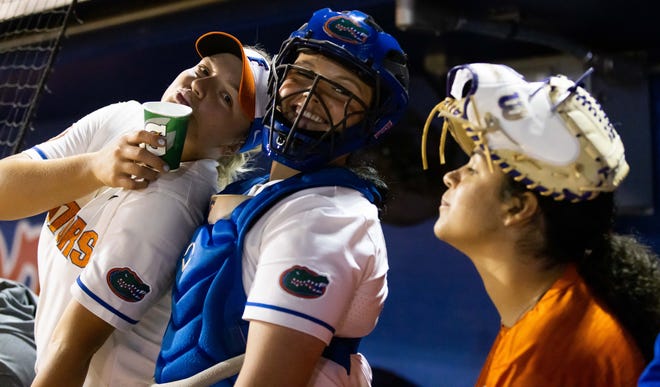 Florida infielder Reagan Walsh (15), left and Florida starting pitcher/relief pitcher Lexie Delbrey (16) ham it up in the dugout during the seventh inning as Manager Kelly Montilla wears her rally glove on her head.The Florida women’s softball team hosted USF at Katie Seashole Pressly Stadium in Gainesville, FL on Wednesday, April 19, 2023. Florida won 7-3 by hitting a grand slam in the bottom of the seventh inning. [Doug Engle/Gainesville Sun]