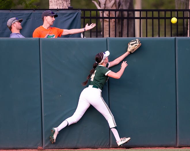 South Fla. utility Alexa Galligani (4) tries to catch a fly ball as Florida infielder Reagan Walsh (15) hits a home run in the bottom of the first making 2-0. The Florida women’s softball team hosted USF at Katie Seashole Pressly Stadium in Gainesville, FL on Wednesday, April 19, 2023. Florida won 7-3 by hitting a grand slam in the bottom of the seventh inning. [Doug Engle/Gainesville Sun]