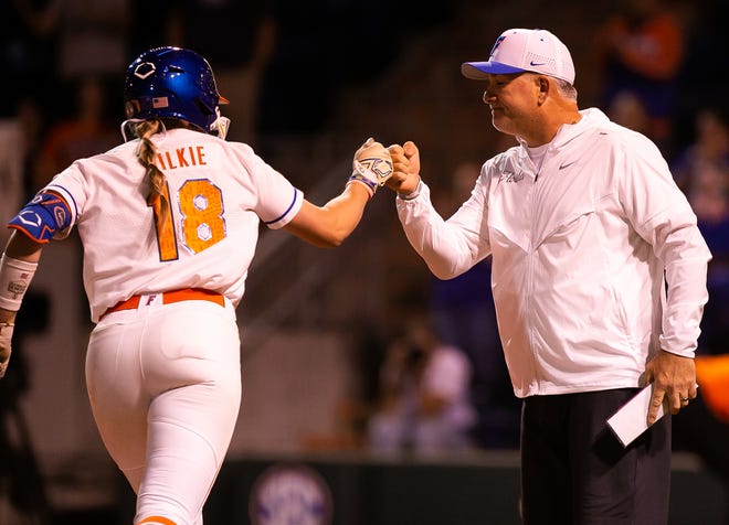 Florida Head Coach Tim Walton gives a fist bump to Florida utility Emily Wilkie (18) as she round third after her grand slam in the bottom of the seventh to win the game 7-3. The Florida women’s softball team hosted USF at Katie Seashole Pressly Stadium in Gainesville, FL on Wednesday, April 19, 2023. Florida won 7-3 by hitting a grand slam in the bottom of the seventh inning. [Doug Engle/Gainesville Sun]The Florida women’s softball team hosted USF at Katie Seashole Pressly Stadium in Gainesville, FL on Wednesday, April 19, 2023. Florida won 7-3 by hitting a grand slam in the bottom of the seventh inning. [Doug Engle/Gainesville Sun]
