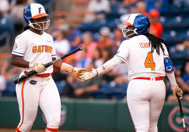 Florida catcher Sam Roe (13) and Florida third baseman Charla Echols (4) give each other a high-five after Roe scored in the bottom of the second.The Florida women’s softball team hosted USF at Katie Seashole Pressly Stadium in Gainesville, FL on Wednesday, April 19, 2023. Florida won 7-3 by hitting a grand slam in the bottom of the seventh inning. [Doug Engle/Gainesville Sun]