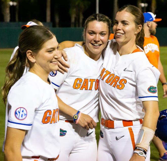 Florida utility Sarah Longley (52), right,  gives Florida utility Emily Wilkie (18) a hug after the game. Wilkie hit a grand slam to win the game. The Florida women’s softball team hosted USF at Katie Seashole Pressly Stadium in Gainesville, FL on Wednesday, April 19, 2023. Florida won 7-3 by hitting a grand slam in the bottom of the seventh inning. [Doug Engle/Gainesville Sun]