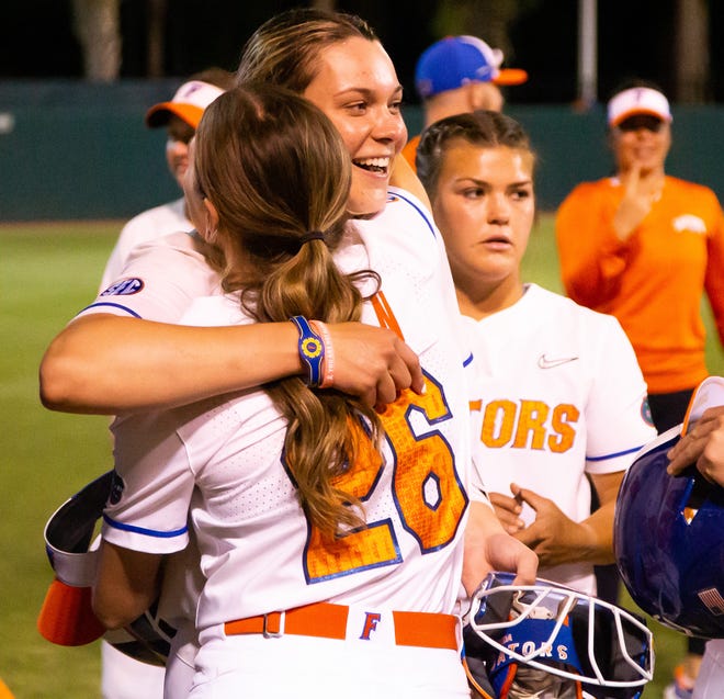 Florida outfielder Christina Wellen (26) gives Florida utility Emily Wilkie (18) a hug after the game. Wilkie hit a grand slam to win the game. The Florida women’s softball team hosted USF at Katie Seashole Pressly Stadium in Gainesville, FL on Wednesday, April 19, 2023. Florida won 7-3 by hitting a grand slam in the bottom of the seventh inning. [Doug Engle/Gainesville Sun]