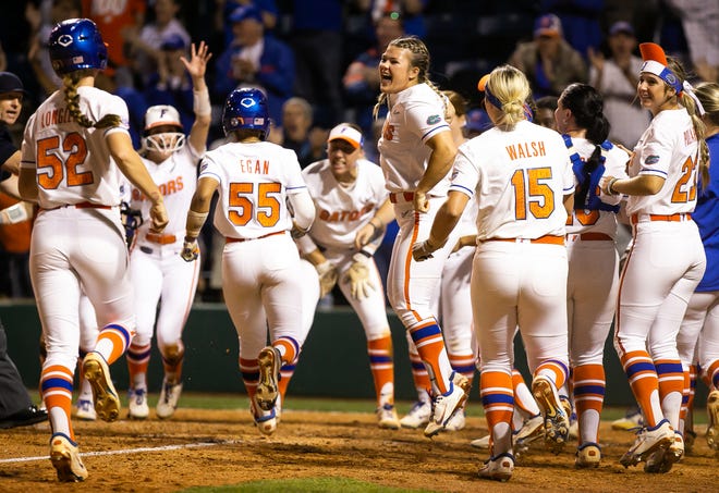 The Florida dugout emptied onto home plate to celebrate Florida utility Emily Wilkie’s (18) grand slam in the bottom of the seventh to win the game 7-3. The Florida women’s softball team hosted USF at Katie Seashole Pressly Stadium in Gainesville, FL on Wednesday, April 19, 2023. Florida won 7-3 by hitting a grand slam in the bottom of the seventh inning. [Doug Engle/Gainesville Sun]The Florida women’s softball team hosted USF at Katie Seashole Pressly Stadium in Gainesville, FL on Wednesday, April 19, 2023. Florida won 7-3 by hitting a grand slam in the bottom of the seventh inning. [Doug Engle/Gainesville Sun]