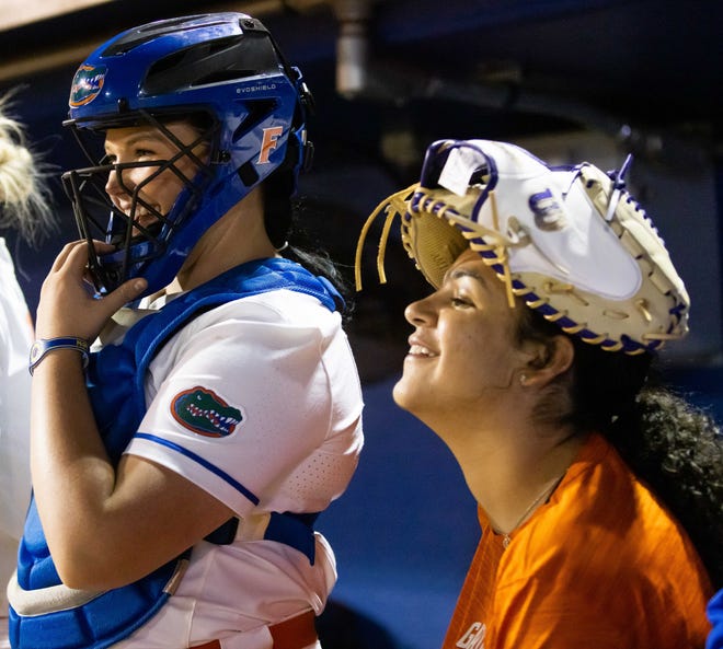 Florida pitcher Lexie Delbrey (16) left, hams it up in the dugout during the seventh inning as Manager Kelly Montilla wears her rally glove on her head.The Florida women’s softball team hosted USF at Katie Seashole Pressly Stadium in Gainesville, FL on Wednesday, April 19, 2023. Florida won 7-3 by hitting a grand slam in the bottom of the seventh inning. [Doug Engle/Gainesville Sun]