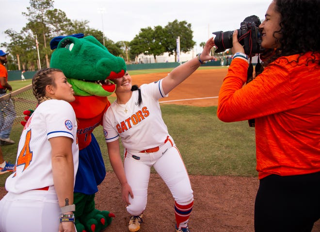 Florida pitcher Rylee Trlicek (44) and Florida pitcher Lexie Delbrey (16), right pose for pictures with Alberta as Manager Kelly Montilla takes their pictures.The Florida women’s softball team hosted USF at Katie Seashole Pressly Stadium in Gainesville, FL on Wednesday, April 19, 2023. Florida won 7-3 by hitting a grand slam in the bottom of the seventh inning. [Doug Engle/Gainesville Sun]