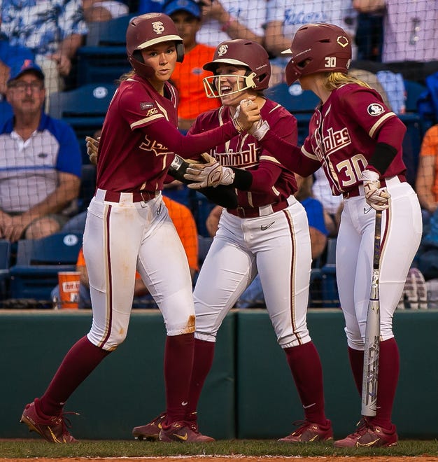 Florida St. Seminoles infielder Devyn Flaherty (9), Florida St. Seminoles outfielder Hallie Wacaser (1) and Florida St. Seminoles infielder Avery Weisbrook (30) congratulate each other after scoring in the fifth. The Florida women’s softball team hosted FSU at Katie Seashole Pressly Stadium in Gainesville, FL on Wednesday, May 3, 2023. The Seminoles defeated the Gators 8-7.  [Doug Engle/Gainesville Sun]