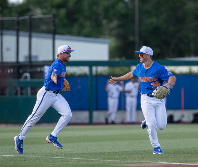 Florida utility Wyatt Langford (36) gets a high five from  Florida infielder Colby Halter (5) after his catch against Texas Tech in Round 2 of NCAA Regionals, Saturday, June 3, 2023, at Condron Family Ballpark in Gainesville, Florida. The Gators fell to the Red Raiders 5-4. They will face U Conn Sunday. [Cyndi Chambers/ Gainesville Sun] 2023
