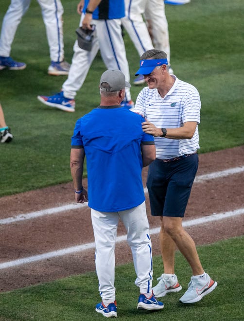 Gators head coach Kevin OÕ Sullivan gets a congratulatory handshake from Athletic Director Scott Stricklin in celebration of FloridaÕs win over South Carolina in Game 2 of the NCAA Super Regional, Saturday, June 10, 2023, at Condron Family Ballpark in Gainesville, Florida. The Gators beat the Gamecocks 4-0 and are headed to the College World Series in Omaha.  [Cyndi Chambers/ Gainesville Sun] 2023
